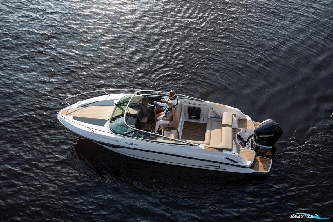 A person drives a Flipper 700 DC boat on shimmering water, showcasing its sleek design and outdoor seating area.